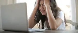 Chica delante de ordenador al recibir una multa por retirar amianto