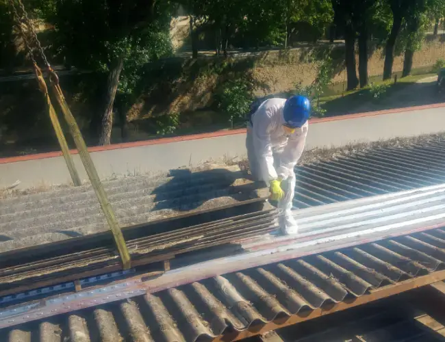 Trabajador retirando residuos RCD peligrosos durante la gestión de residuos de construcción y demolición.