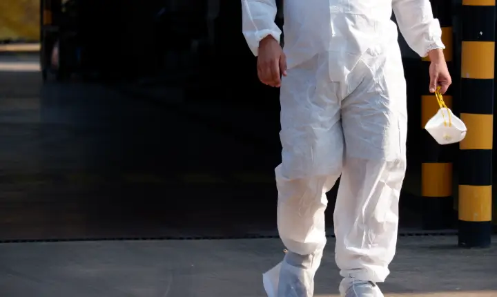 Treballador amb vestit de protecció blanc i màscara FFP3 a la mà, durant les tasques de retirada d’amiant a les instal·lacions del metro de Barcelona.