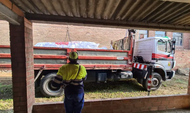 Operario supervisando la carga de un paquete sellado con materiales con amianto retirados del metro de Barcelona, preparado para su transporte seguro.